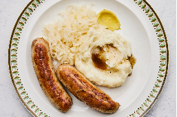 brats, mashed potatoes, sauerkraut on plate